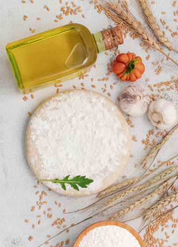 Photo d'ingrédients de base : huile d'olive, blé, farine, pâte à pizza, épis de blés, tomate, ail
